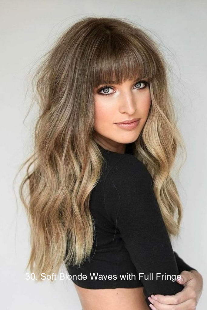 30. Soft Blonde Waves with Full Fringe